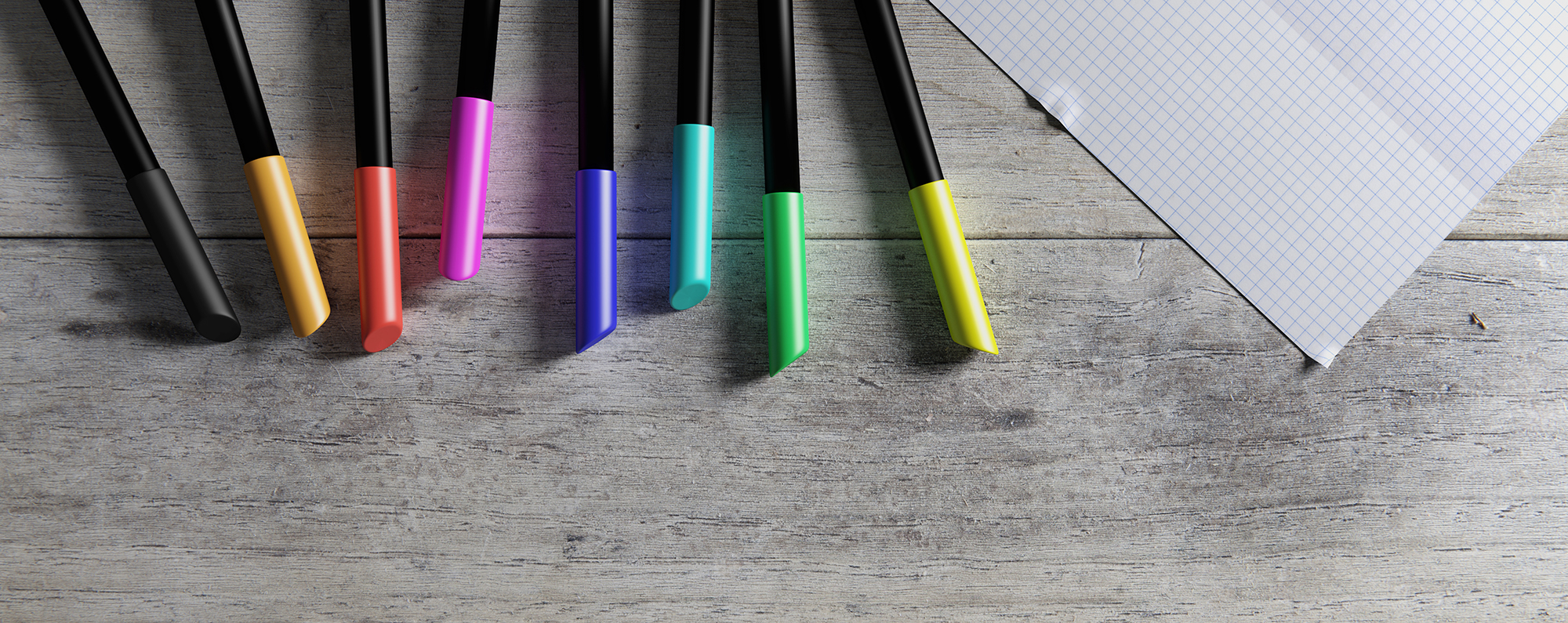 sheet of paper with colored pencils laying on wooden desk